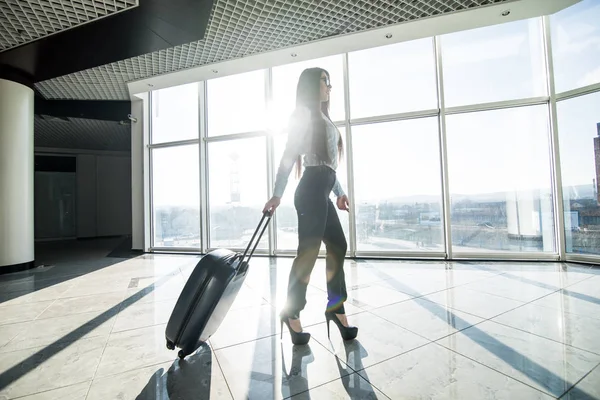 Business woman with luggage in international airport