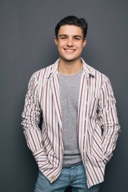 Gri arka plan üzerinde çapraz elleri olan mutlu neşeli adam