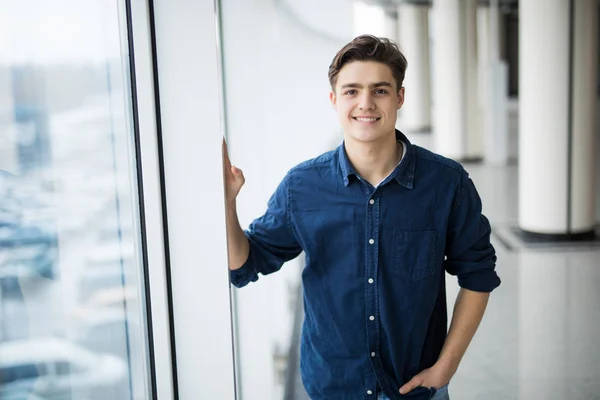 Hombre guapo gesto bien al lado de una ventana — Foto de Stock