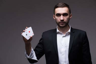 Gri arka plan üzerinde elinde iki iskambil ile adam büyücü