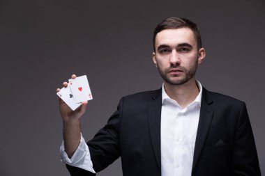 Gri arka plan üzerinde elinde iki iskambil ile adam büyücü