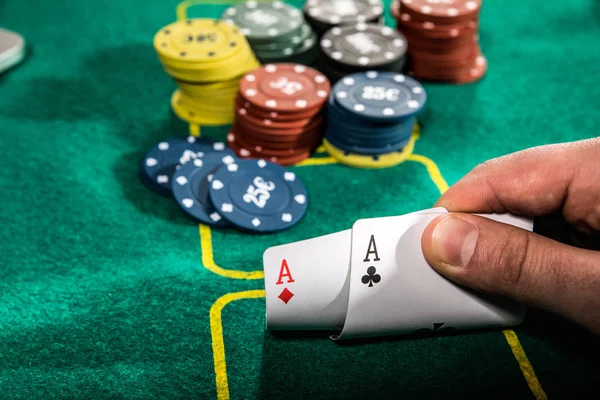 Close up de jogador de poker com dois ases jogando cartas e fichas na mesa de casino verde — Fotografia de Stock