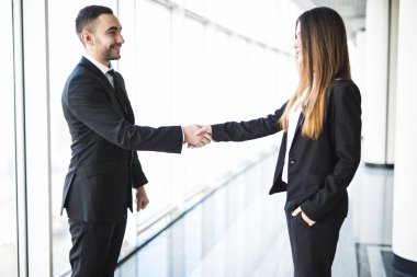 İşadamı ve Office büyük panoramik pencereler ile el sıkışan işkadını