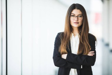 Gülümseyen genç iş kadını silah, office karşı ayakta geçti