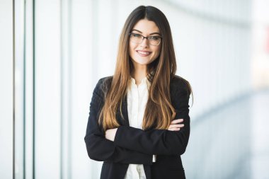 Gülümseyen genç iş kadını silah, office karşı ayakta geçti