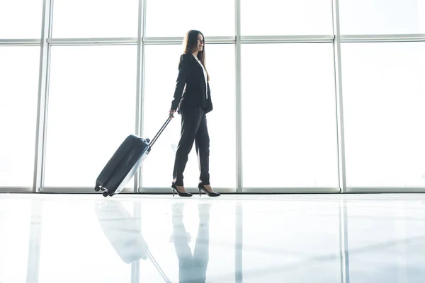 Mulher de negócios com saco de bagagem andando no aeroporto — Fotografia de Stock