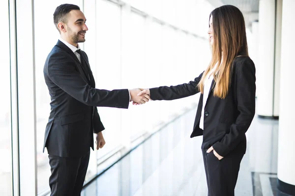 Empresario y Empresario estrechando la mano en la oficina con grandes ventanas panorámicas — Foto de Stock