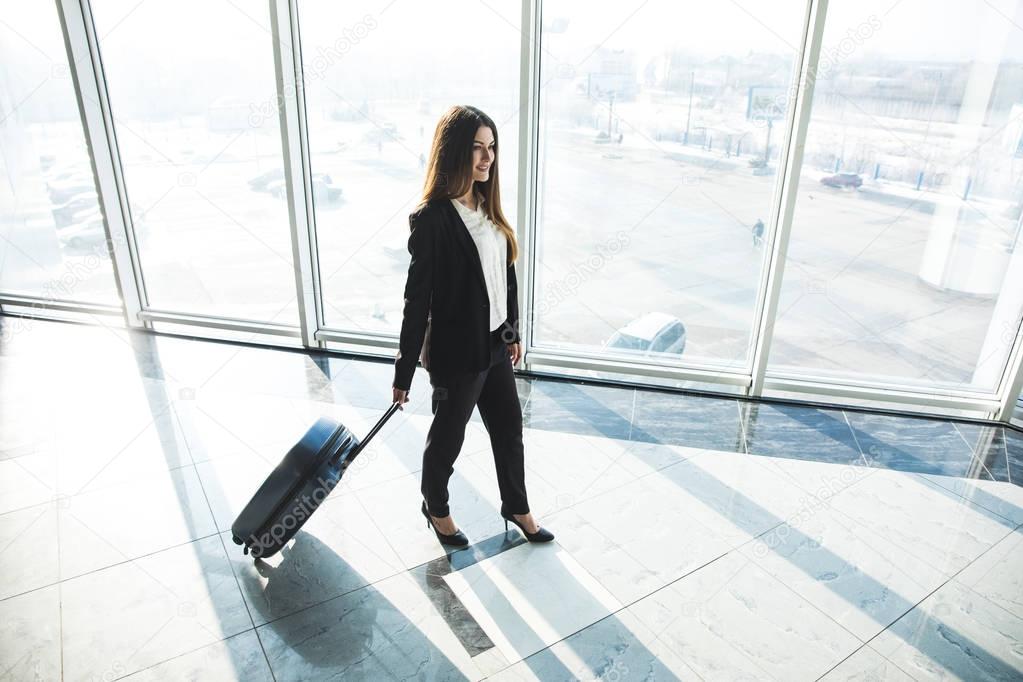 Business woman with laggage bag walking in airport