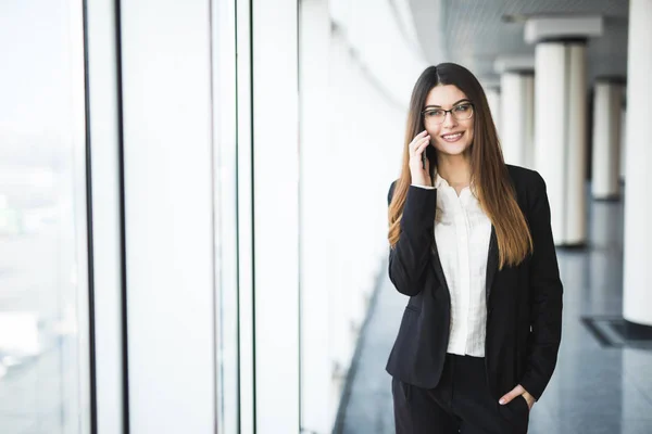 Giovane donna con cellulare in ufficio — Foto Stock