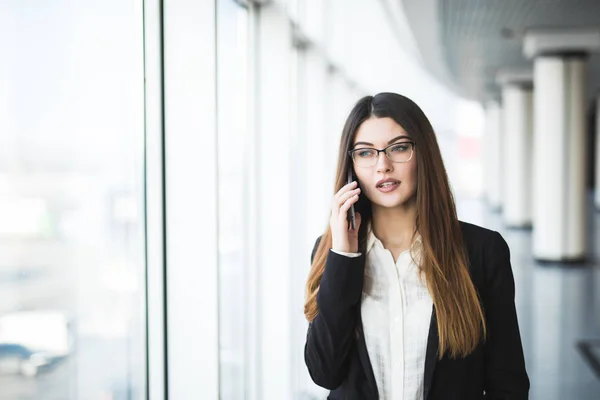 Giovane donna con cellulare in ufficio — Foto Stock