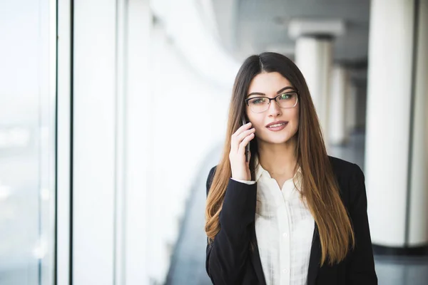 オフィスで携帯電話を持つ若い女性 — ストック写真