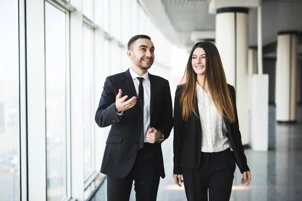 Socios de negocios confiados caminando por la oficina y hablando — Foto de Stock