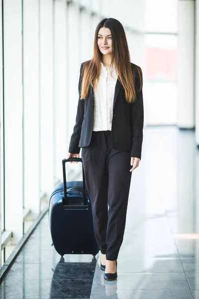 비행기에 탑승 하기 전에 수하물와 함께 산책 하는 매력적인 젊은 비즈니스 여자의 초상화 — 스톡 사진