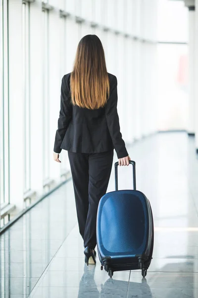 Porträt einer attraktiven jungen Geschäftsfrau, die vor dem Einsteigen im Flugzeug mit Gepäck spazieren geht — Stockfoto