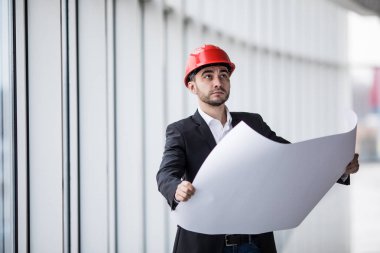 Bina, ciddi inşaat mühendisi şantiye belgeleriyle çalışma düzeni planı okuyan bir mimar Oluşturucu portresi.