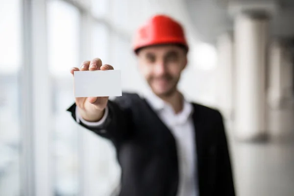 Byggnadsarbetare håller tom visitkort i byggnadsteknik. — Stockfoto