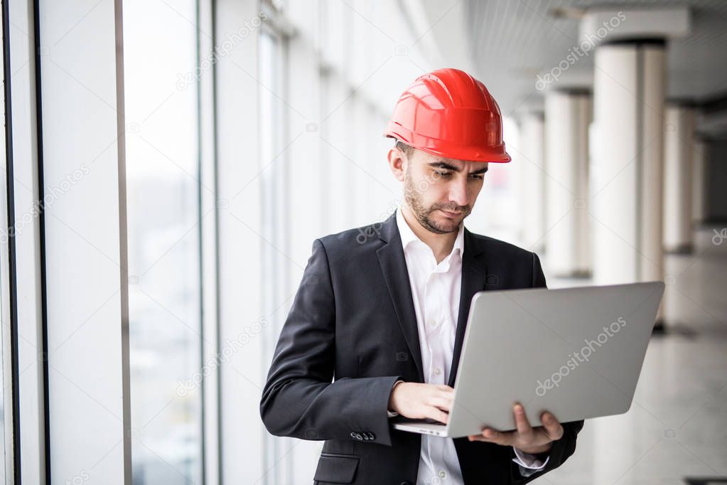 Handsome male engineer is using a notebook for work.
