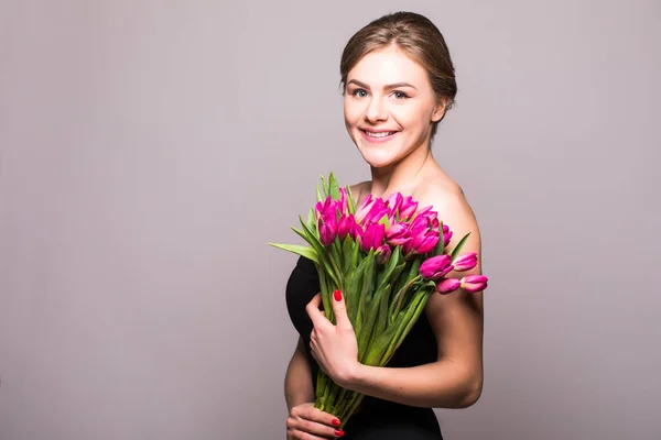 Όμορφο κορίτσι με τουλίπες λουλούδια σε χέρια σε ανοιχτόχρωμο φόντο — Φωτογραφία Αρχείου