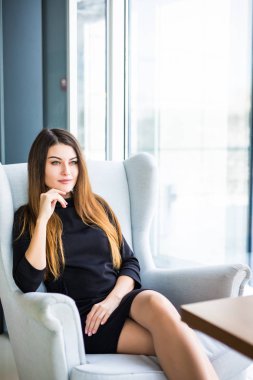 Bir kafede çalışırken bir iskemlede çekici genç kadın