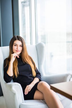 Bir kafede çalışırken bir iskemlede çekici genç kadın