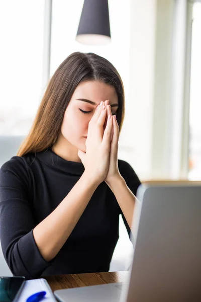 Mujer joven meditando sentada en el escritorio de la oficina moderna frente a la computadora portátil, tomando una pausa, ocupado, oficina estresante, cura para la sobrecarga de trabajo, meditación de un momento — Foto de Stock