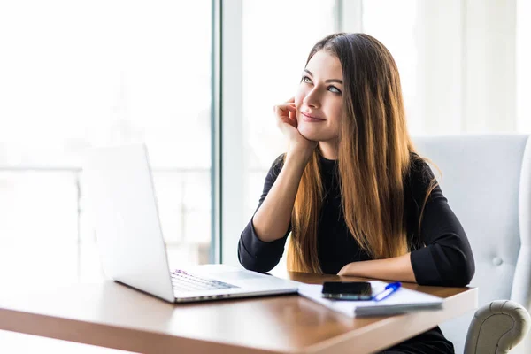Jonge mooie zakenvrouw met laptop in de lichte, moderne kantoor — Stockfoto