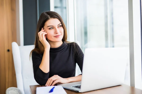 Jonge mooie zakenvrouw met laptop in de lichte, moderne kantoor — Stockfoto