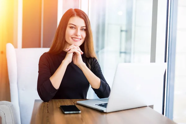 Mooie vrouw werken op haar laptop op een stijlvolle, stedelijke restaurant — Stockfoto