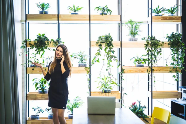 Donna alla moda hanno smart phone conversazione mentre in piedi in ambiente urbano, giovane donna d'affari parlando sul suo telefono cellulare in mensa — Foto Stock