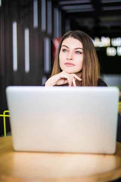 Mujer emprendedora que trabaja con un portátil en una cafetería o hub smart space — Foto de Stock