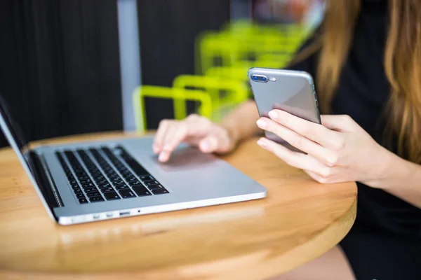 Vrouwelijke handen te typen op het toetsenbord van de computer en telefoon — Stockfoto