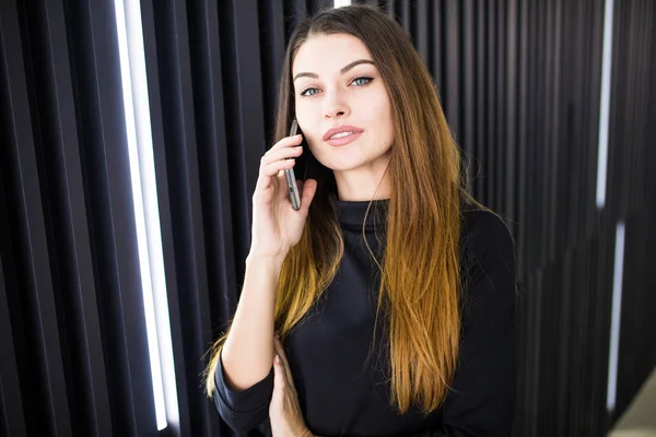 Szabadúszó üzleti nő beszél a mozgatható telefon-val Hivatal szobában a háttérben — Stock Fotó