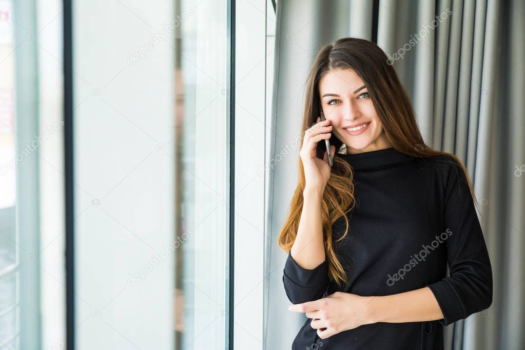 Smiling woman talking on phone in office