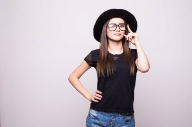 Genç kız duygu yapıyor. Siyah gömlek, siyah şapka, gözlük Studio giymiş