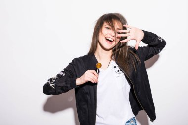 Genç güzel kız Chupa chups gri arka plan üzerinde yemek.