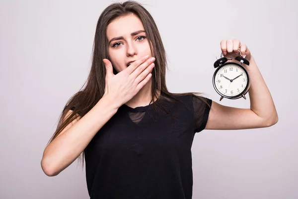 Giovane donna sorridente con sveglia isolato sfondo bianco parete grigia. Espressione del volto umano . — Foto Stock