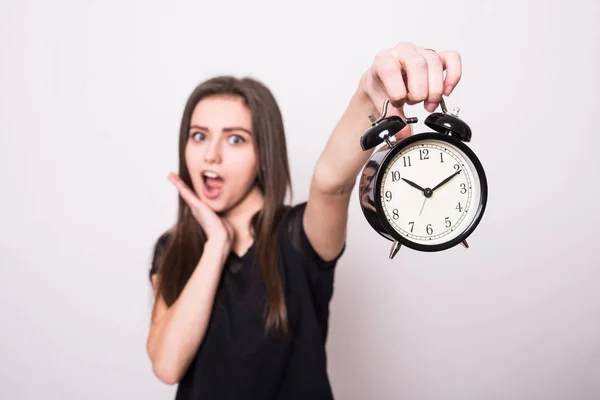 Mulher feliz segurando relógio contra um cinza — Fotografia de Stock