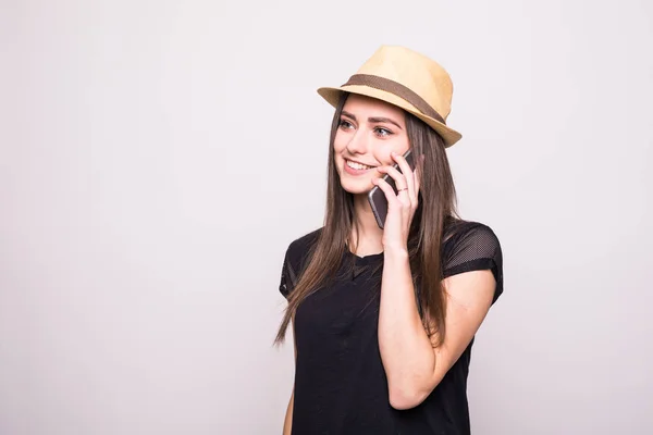 Chica alegre en gorra hablar en el teléfono inteligente en gris —  Fotos de Stock