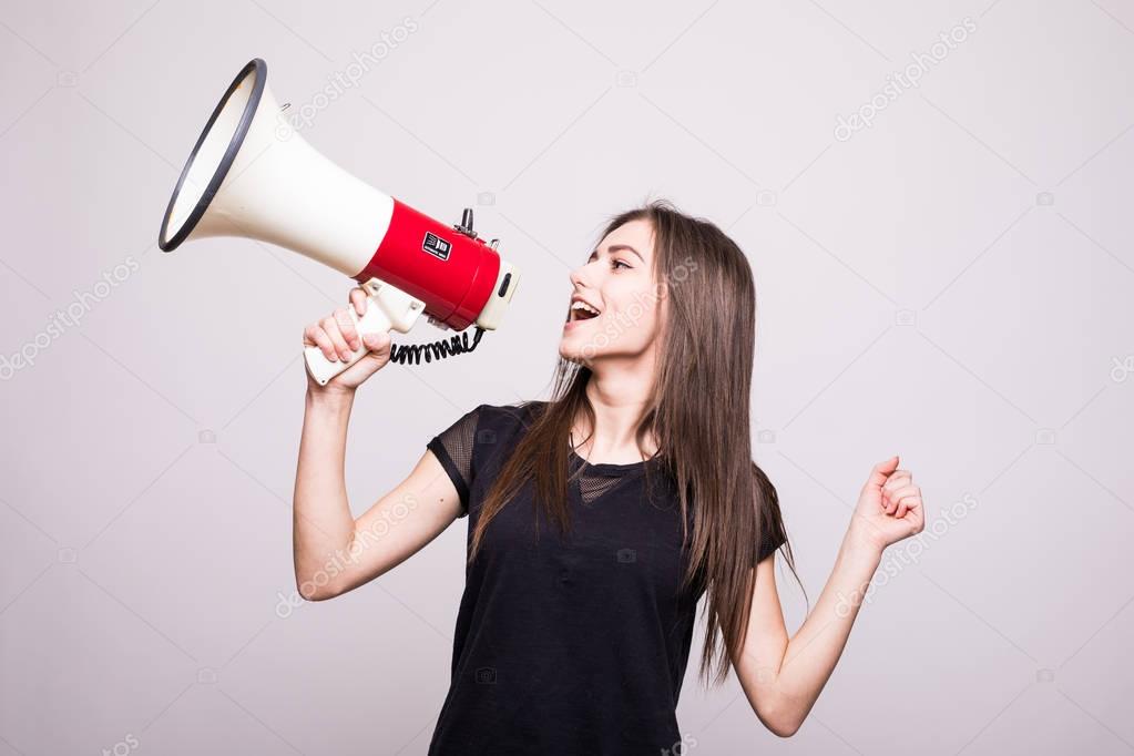 Pretty girl shouting into megaphone on copy space