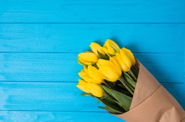 Sarı Lale mavi ahşap arka plan üzerinde buket.