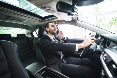 Araba sürüş sırasında onun telefonu kullanan adam. İş adamı sürücü konuşmak telefon beyaz sürücü araç