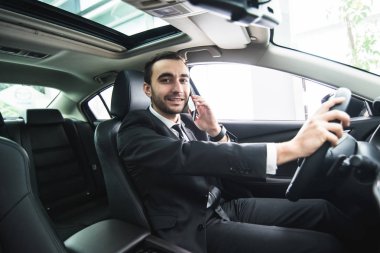 Araba sürüş sırasında onun telefonu kullanan adam. İş adamı sürücü konuşmak telefon beyaz sürücü araç