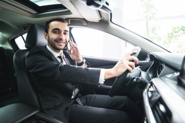 Araba sürüş sırasında onun telefonu kullanan adam. İş adamı sürücü konuşmak telefon beyaz sürücü araç