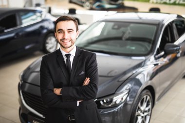 Galeride ayakta yakışıklı genç klasik araba satıcısı