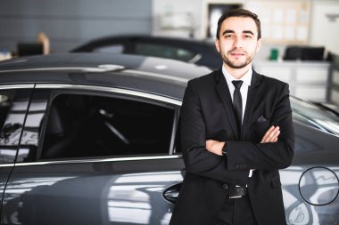Galeride ayakta yakışıklı genç klasik araba satıcısı