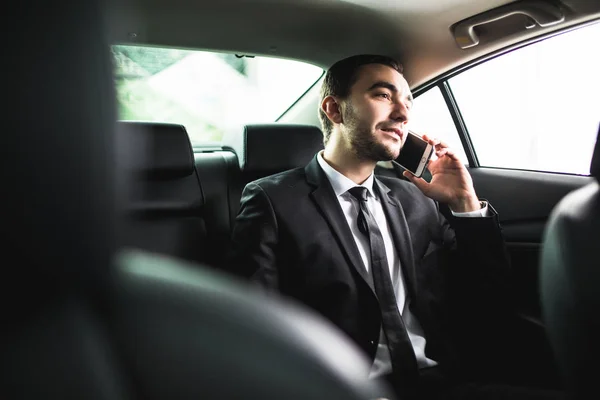 Businessman on call in car, smiling — Stock Photo, Image