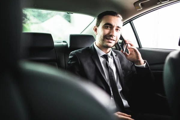 Businessman on call in car, smiling — Stock Photo, Image