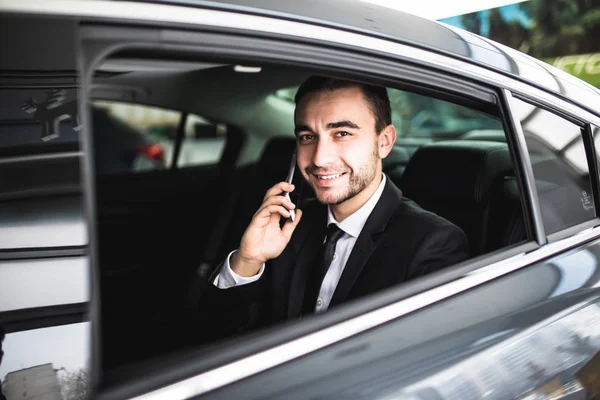 Lächeln Geschäftsmann mit seinem Handy im Auto — Stockfoto