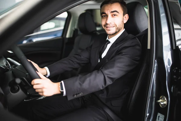 Jovem sorrindo enquanto dirige em seu carro — Fotografia de Stock