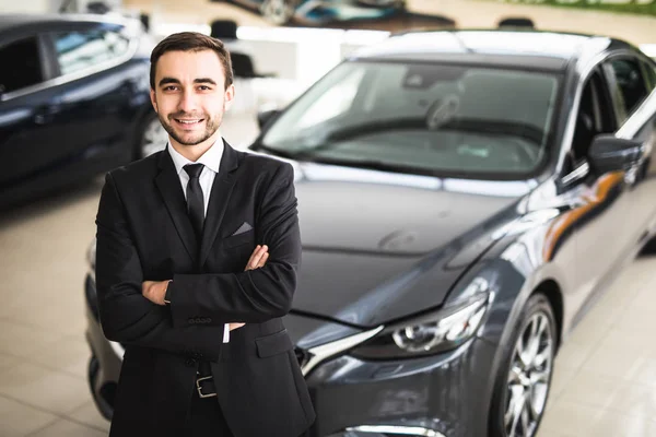 Galeride ayakta yakışıklı genç klasik araba satıcısı